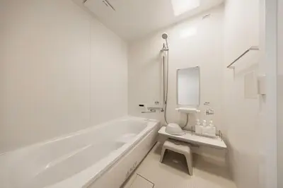 a white bathroom with a tub and a toilet and a sink at Lino Stay Kasai 'ekol in Tokyo