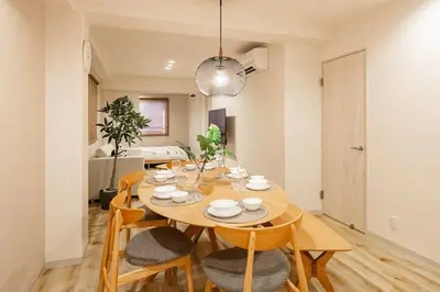 a dining room with a wooden table and chairs at Lino Stay Kasai 'ekol in Tokyo