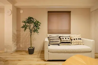 a living room with a couch and a potted plant at Lino Stay Kasai 'ekol in Tokyo