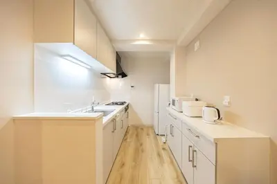 a white kitchen with a sink and a refrigerator at Lino Stay Kasai 'ekol in Tokyo