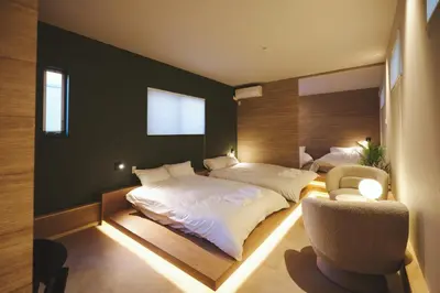 a bedroom with two beds and a chair at Ebisu4HOTEL in Tokyo