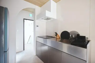 a kitchen with white walls and a black counter top at Ebisu4HOTEL in Tokyo