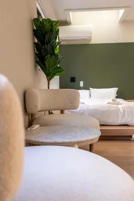 a room with a bed and a chair with a plant at Ebisu4HOTEL in Tokyo