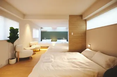a hotel room with two beds and a couch at Ebisu4HOTEL in Tokyo
