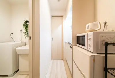 a small kitchen with a microwave and a sink at Imb\u753a\u5c4b4\u4e01\u76ee201 in Tokyo