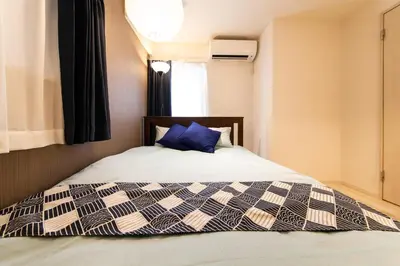 a bedroom with a bed with a blue pillow at Imb\u753a\u5c4b4\u4e01\u76ee201 in Tokyo