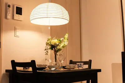 a dining room table with a chandelier and flowers on it at Imb\u753a\u5c4b4\u4e01\u76ee201 in Tokyo