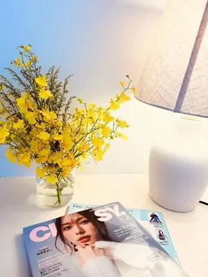 a magazine and a vase with yellow flowers on a table at Higashijūjō, Kita City house KI0321 in Tokyo