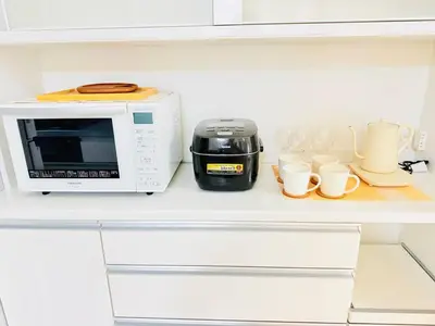 a microwave and coffee cups on a shelf in a kitchen at Higashijūjō, Kita City house KI0321 in Tokyo