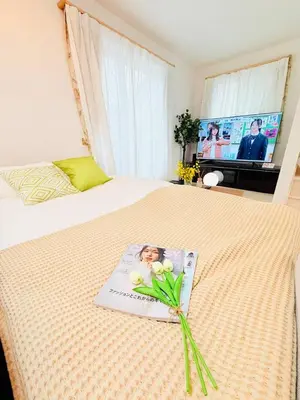 a magazine on a bed with flowers on it at Higashijūjō, Kita City house KI0321 in Tokyo
