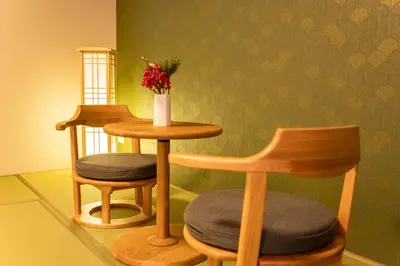 a room with two chairs and a table with a vase of flowers at HOTEL Grand Star TATEISHI SEVEN in Tokyo