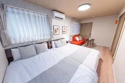 a bedroom with a large white bed and a red chair at HOTEL Grand Star TATEISHI SEVEN in Tokyo