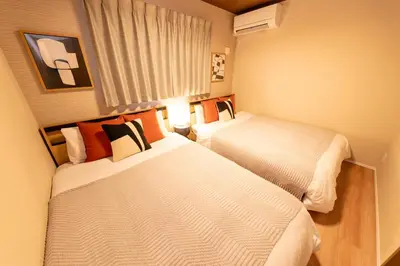 a hotel room with two beds and a window at HOTEL Grand Star TATEISHI SEVEN in Tokyo