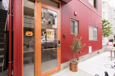 a red house with a pumpkin sign on the door at GrapeHouse Koenji in Tokyo