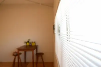 a window with blinds on a wall with a table at GrapeHouse Koenji in Tokyo
