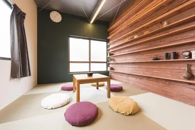a room with a table and four cushioned chairs at GrapeHouse Koenji in Tokyo