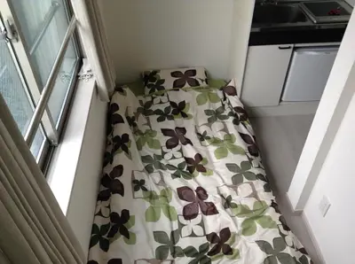a small bedroom with a bed with flowers on it at Shitamachi Base in Tokyo