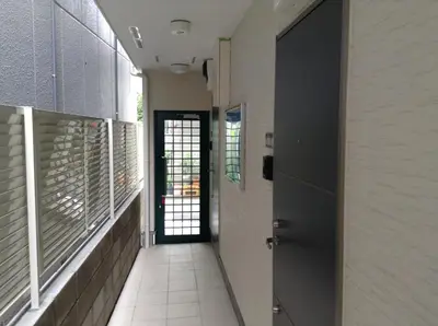 a hallway with a door and a tile floor at Shitamachi Base in Tokyo