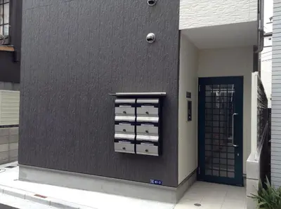 a building with a black wall with three filing cabinets at Shitamachi Base in Tokyo