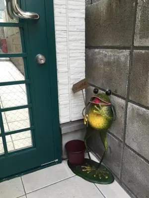 a toy frog is standing next to a door at Shitamachi Base in Tokyo