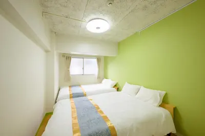 two beds in a small room with a window at HANEZORA HOTEL itabashi 3F4F in Tokyo