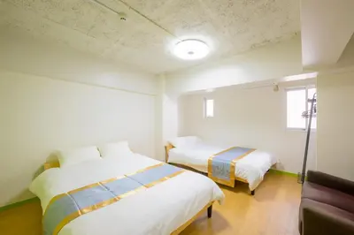 two beds in a room with white walls at HANEZORA HOTEL itabashi 3F4F in Tokyo
