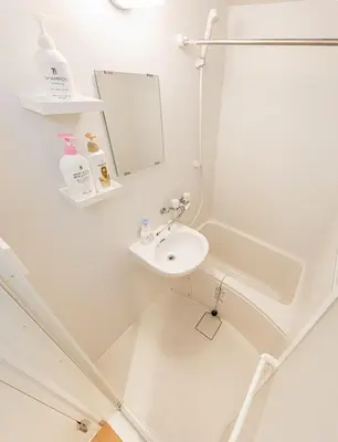 a white bathroom with a sink and a mirror at 67 Apartment Hotel Asakusa in Tokyo