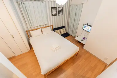 a bedroom with a bed with a book on it at 67 Apartment Hotel Asakusa in Tokyo