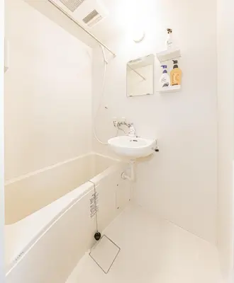 a white bathroom with a sink and a bath tub at 67 Apartment Hotel Asakusa in Tokyo