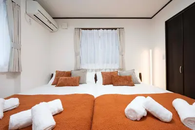 a bedroom with a large bed with towels on it at All Good Stay KAMEARI in Tokyo