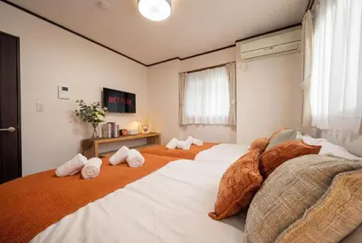 a bedroom with three beds with stuffed animals on them at All Good Stay KAMEARI in Tokyo