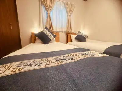 two beds in a hotel room with twoermottermott at Nexus Villa Morishita in Tokyo