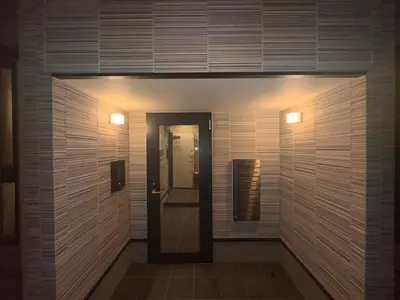 a bathroom with a walk in shower next to a door at Nexus Villa Morishita in Tokyo
