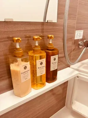 four bottles of soap on a shelf in a bathroom at Nexus Villa Morishita in Tokyo