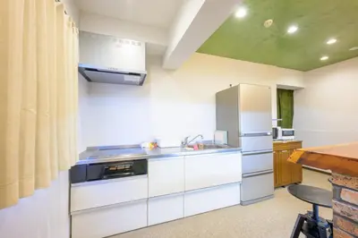 a kitchen with a sink and a refrigerator at HANEZORA HOTEL itabashi 2F in Tokyo