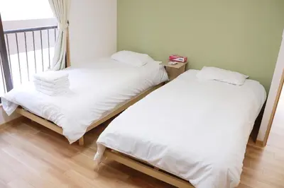 two beds with white sheets in a room with a window at SunRiseStay Asakusa Kaminarimon-dori\u6d45\u8349\u5546\u4e1a\u8857 \u96f7\u95e8\u901a in Tokyo