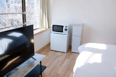 a living room with a television and a microwave at SunRiseStay Asakusa Kaminarimon-dori\u6d45\u8349\u5546\u4e1a\u8857 \u96f7\u95e8\u901a in Tokyo