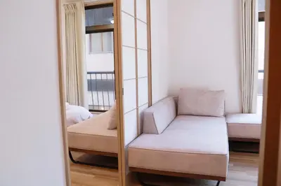 a mirror with a couch and a chair in a room at SunRiseStay Asakusa Kaminarimon-dori\u6d45\u8349\u5546\u4e1a\u8857 \u96f7\u95e8\u901a in Tokyo