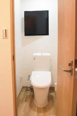 a bathroom with a toilet with a tv on the wall at SunRiseStay Asakusa Kaminarimon-dori\u6d45\u8349\u5546\u4e1a\u8857 \u96f7\u95e8\u901a in Tokyo
