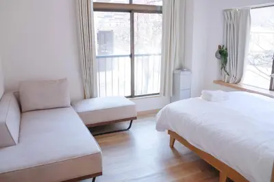 a bedroom with a bed and a couch and a window at SunRiseStay Asakusa Kaminarimon-dori\u6d45\u8349\u5546\u4e1a\u8857 \u96f7\u95e8\u901a in Tokyo