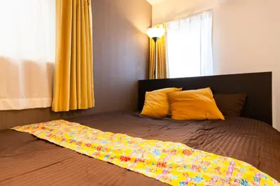 a bed with a colorful blanket on top of it at Imb\u753a\u5c4b4\u4e01\u76ee301 in Tokyo