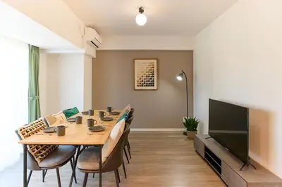 a dining room with a table and a tv at VORT Yamabukicho Residence in Tokyo