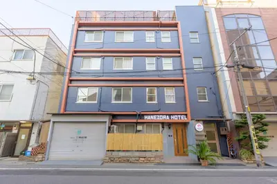 a blue building on a city street at HANEZORA HOTEL itabashi 1F in Tokyo