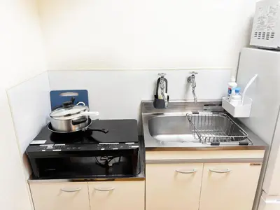 a small kitchen with a stove and a sink at TOKYONATIVES Kugahara Base in Tokyo