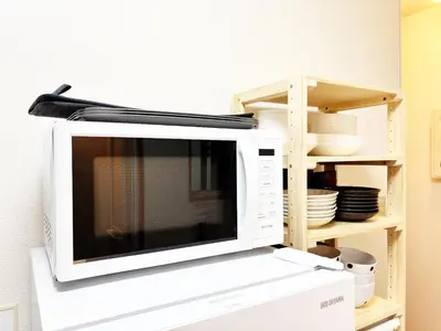 a microwave oven sitting on top of a box at TOKYONATIVES Kugahara Base in Tokyo