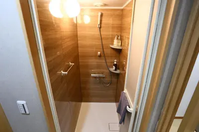 a bathroom with a shower with wooden walls at Direct Skytree View I Easy Airport Access I New 2025 Building in Tokyo