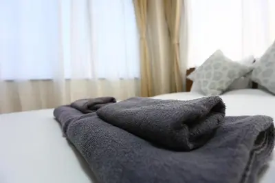 a gray blanket on a bed in front of a window at Direct Skytree View I Easy Airport Access I New 2025 Building in Tokyo