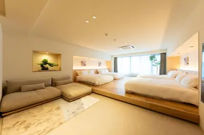 two beds and a couch in a room at THE AKI Daimon in Tokyo