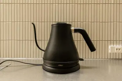 a black kettle sitting on a counter next to a wall at THE AKI Daimon in Tokyo