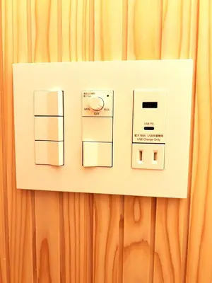 a lightswitch on a wall next to a curtain at THE AKI Daimon in Tokyo